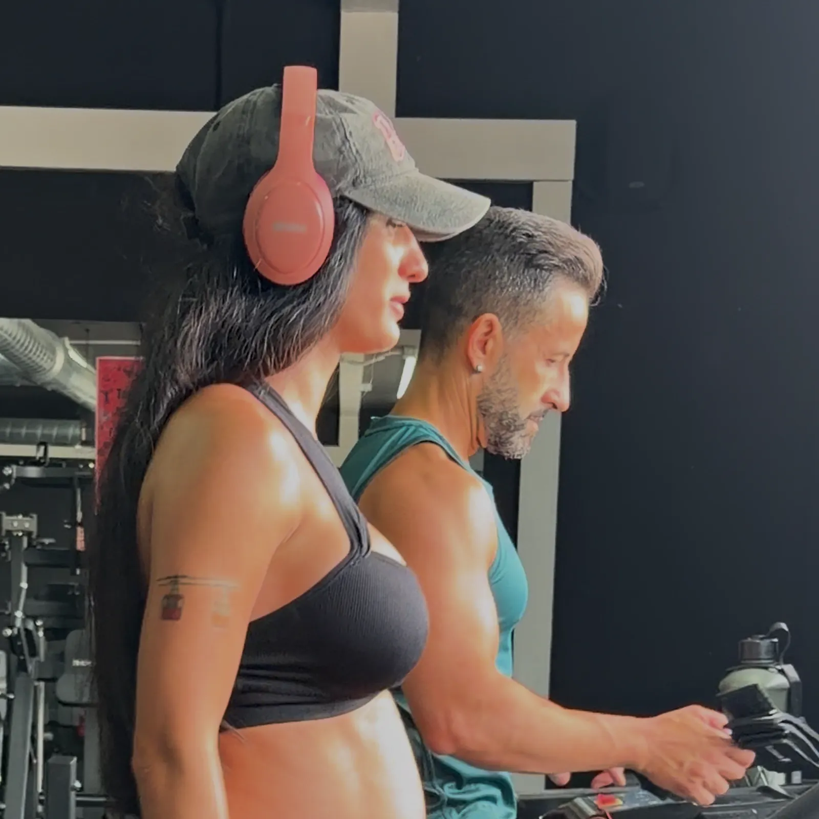 Mujer y hombre caminando en las cintas de la sala de cardio