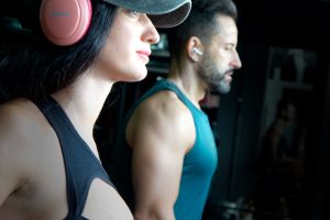 Una socia con cascos y gorra y un socio con camiseta verde entrenan en la sala de Power Zone