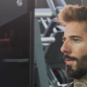 Socio concentrado soltando el aire en plena repetición, en la sala de musculación