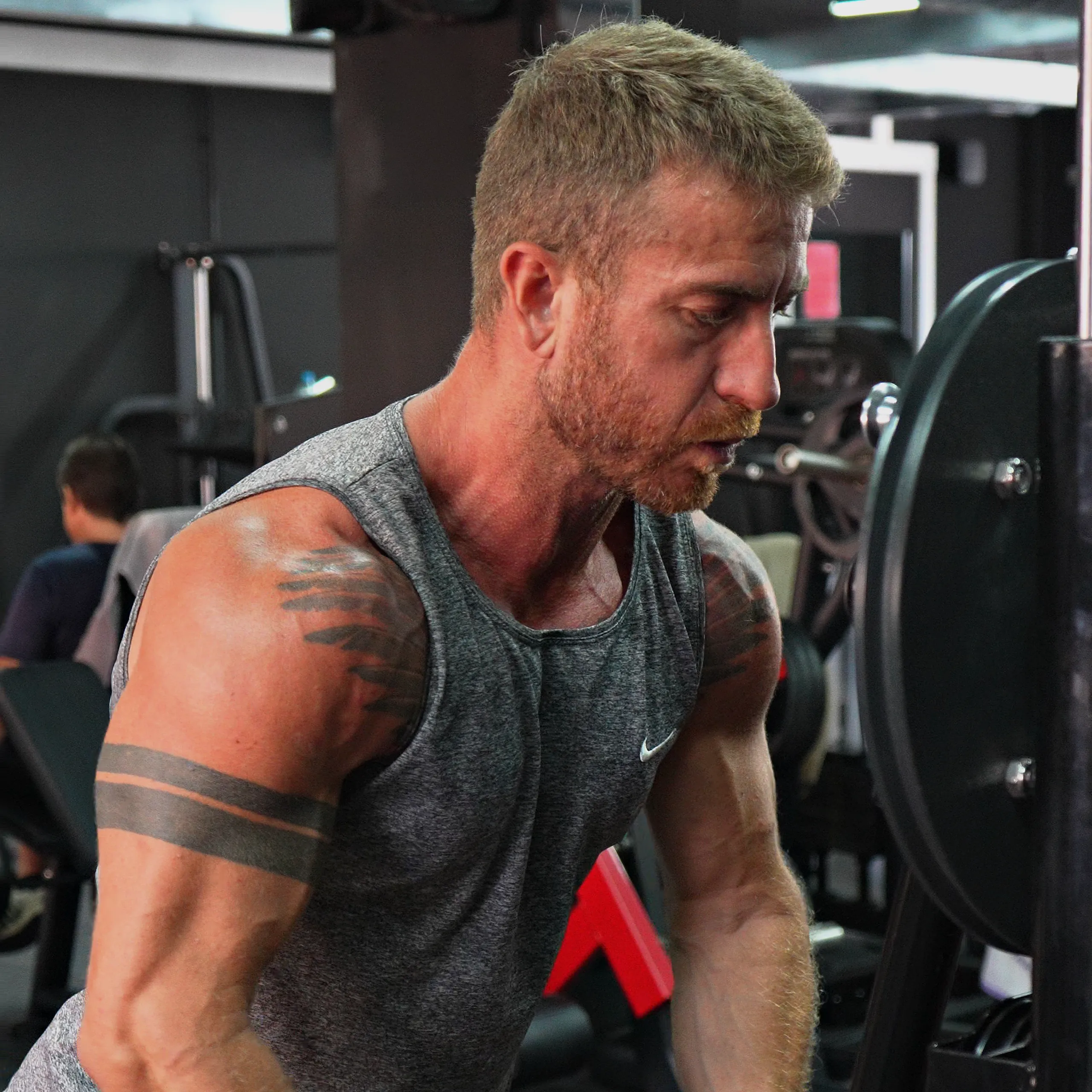 Socio haciendo remo con barra en T en la sala de musculación