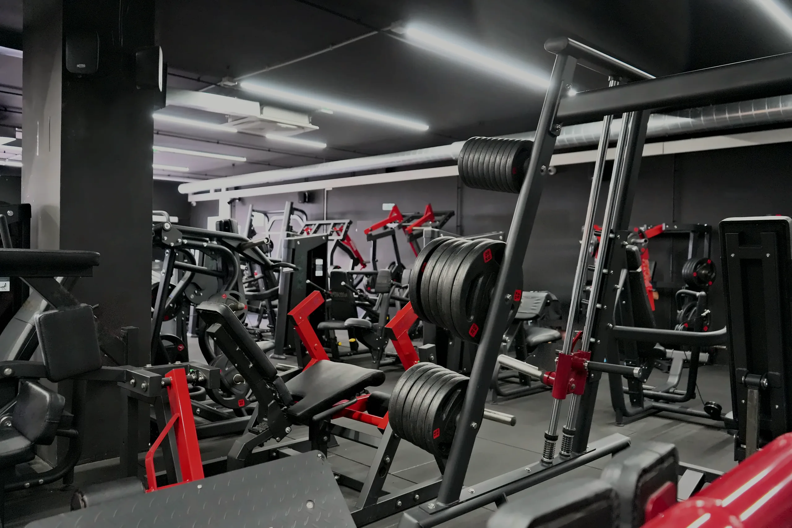 La sala de musculación de Power Zone en Gran Alacant, con máquinas de disco rojas y la jaula de peso libre